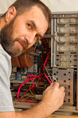 Computer Repair. a man with a beard fixing the system unit