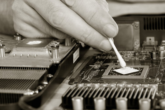 computer repair. applying thermal paste to the video processor. close-up selective focus. black and white photo