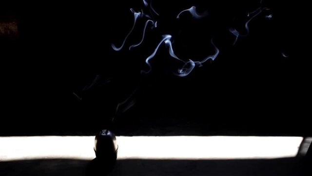 Smoke form aroma sticks ina beam of light inside of a dark room