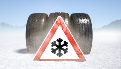 Winterreifen auf Schnee mit Gefahrenzeichen