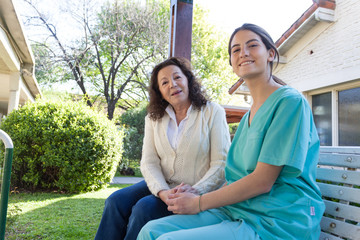 Nurse and patient talking sitting on a park bench