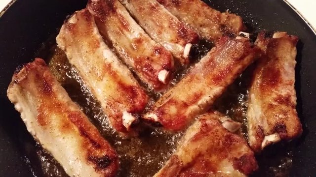 Appetizing fresh pork ribs fried in a pan