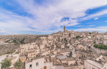 Fototapeta na wymiar panoramic view of typical stones (Sassi di Matera) and church of Matera under blue sky