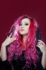 Attractive woman with pink hair in witch image. Halloween style