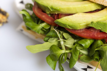Green avocado slices sandwich with tomato and salad