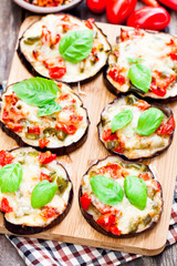 Baked  eggplant with cheese and tomatoes on cutting board