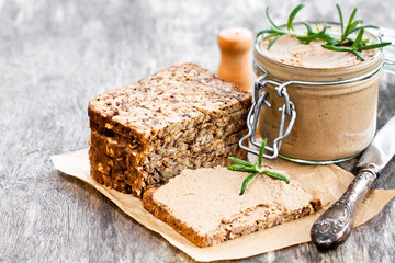 homemadeliver  pate with rosemary in a jar on a rustic table