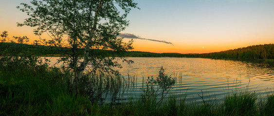 Evening on the lake.Bank of a forest lake at sunset