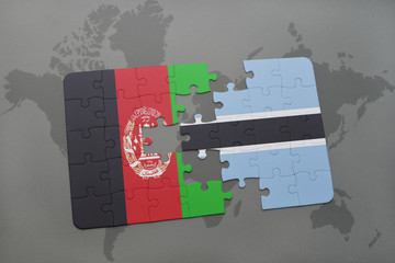 puzzle with the national flag of afghanistan and botswana on a world map background.