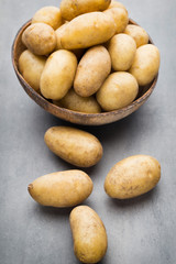 New potato on the bowl, gray background.
