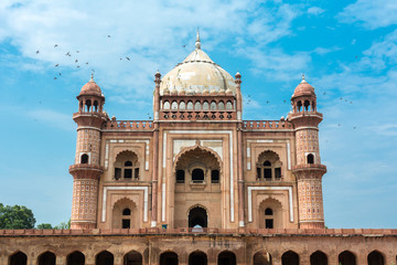 Birds flying over Safdar Jung's Tomb, Delhi, India. Safdarjung's Tomb is a sandstone and marble mausoleum. It was built in 1754 in the late Mughal Empire style for the statesman Safdarjung.

