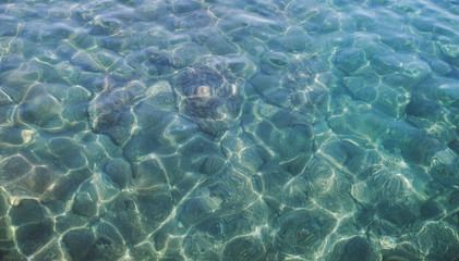 Naklejka na ściany i meble Azure clear seawater covers stones, natural abstract background 