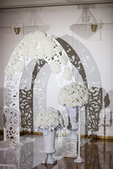 Beautiful wedding ceremony design decoration elements with arch, floral , flowers, chairs indoor