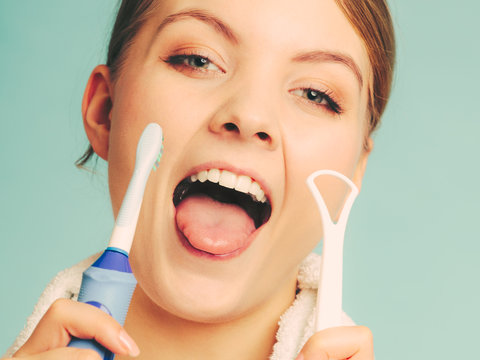 Girl with brush and tongue cleaner.
