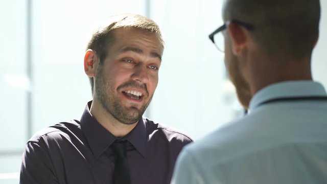 two men talking in the lobby of the office