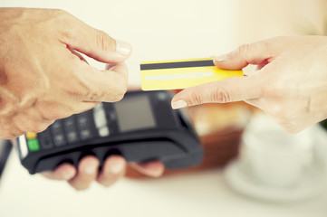 Staff receiving payment by credit card in a coffe shop