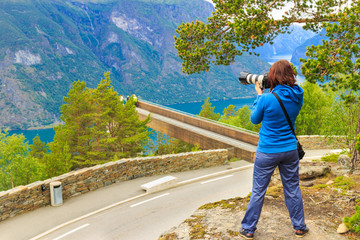 Fototapeta na wymiar Tourist taking photo from Stegastein viewpoint Norway