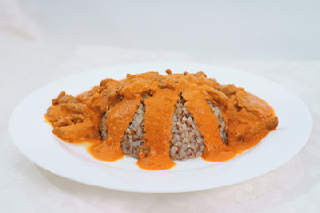 Beef stroganoff with boiled buckwheat served on a white plate