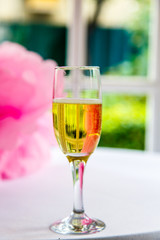 One glass of champagne is a white table against the window on the veranda outside the city. Wedding.