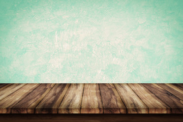 Empty wooden table with green wall background.