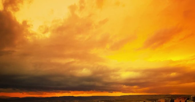 sunset scene with sun fall behind the clouds in background, time lapse shot, warm colorful sky with soft clouds