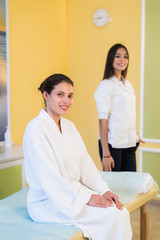 Woman beautician doctor with patient in spa wellness center. Young female professional cosmetologist make neck massage to beautiful brunette girl in cosmetology cabinet or beauty parlor.