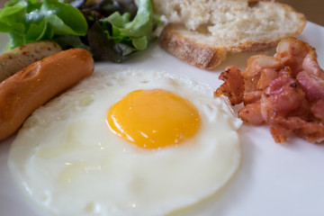 Fried egg with sausage and bacon bread vegetable as breakfast me