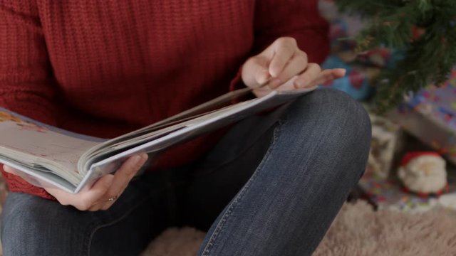 Close up of happy mother hands flipping through photo album