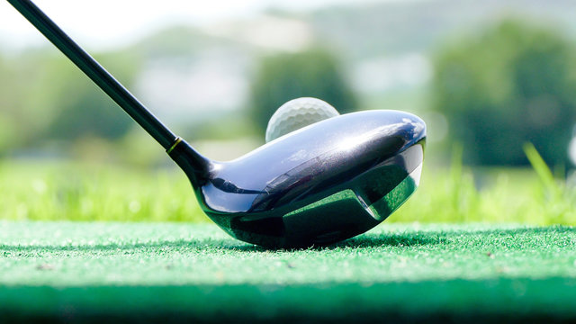 Golf Ball And Putter On Green Grass Of Course