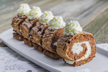 Five pieces Chocolate roll filled with whipped cream on white tr