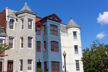 Luxury row houses in Shaw neighborhood in Washington DC. Colorful remodeled townhouses under a blue sky.