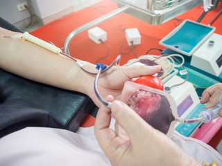 Nurse receiving blood from blood donor in hospital.