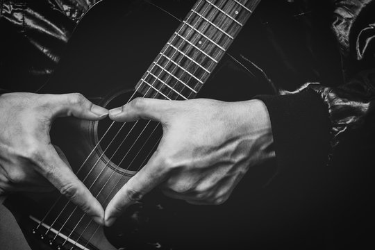 music lover, male hand sign on acoustic guitar. bw filter