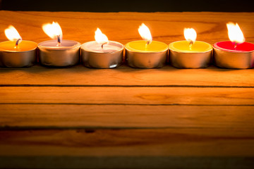 Fototapeta na wymiar candle flames glowing in the dark. candle light on wooden table.