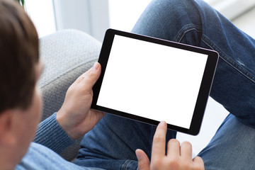 man sitting on sofa holding tablet computer with isolated screen