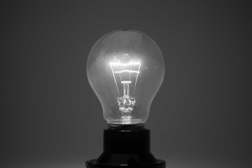 Glowing glass light bulb on dark background