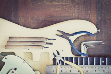 yellow electric guitar on wood in repair & luthier workshop, fixing & musical instrument repairing...