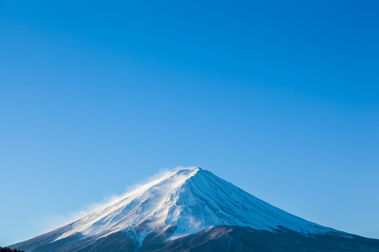 Steamy Mount Fuji peak with clear blue sky in early morning sun