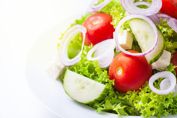 Homemade greek or summer salad with fresh vegetables in a plate with copy space, closeup