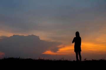 silhouette of woman  enjoys outdoor at sunset
