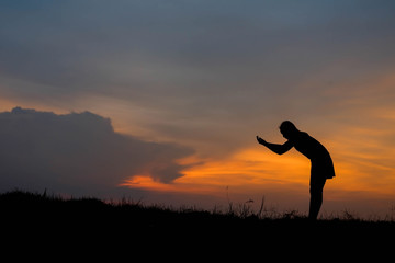 silhouette of woman Standing blessings of god at sunset