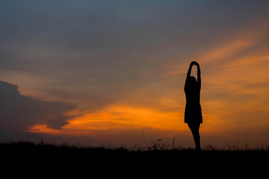 silhouette of woman  enjoys outdoor at sunset