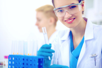 Woman researcher is surrounded by medical vials and flasks, isolated on white background