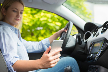 Woman In Car Texting On Mobile Phone Whilst Driving