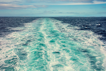Water trail foaming behind a ferry