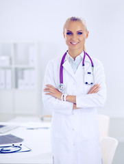 Portrait of young woman doctor with white coat standing in hospital