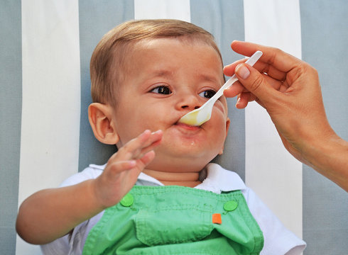 Dando de comer la papilla,compota a un bebe