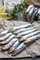 fresh sardines raw fish with coarse salt and thyme on brown pape