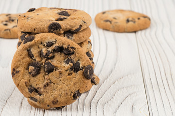 Chocolate cookies closeup on white old wooden table.