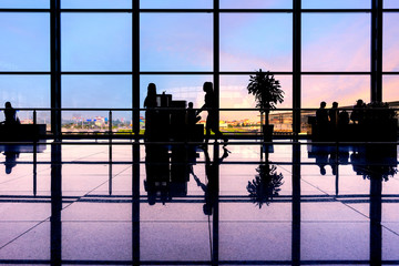 Obraz premium Travelers walk through an airport terminal